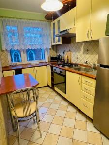 厄尔科Apartament w centrum的厨房配有黄色橱柜、桌子和水槽