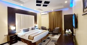 沙鲁拉Address Sharurah Hotel的酒店客房设有一张大床和一台电视。
