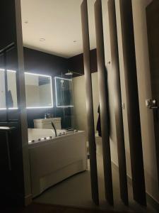 蒙特勒伊Sweet Love Room - Jacuzzi Privatif的浴室配有盥洗盆和浴缸。