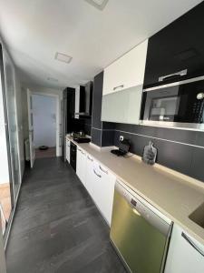 里瓦斯-巴西亚马德里德Apartamento cerca centro Madrid的厨房配有黑白橱柜和台面
