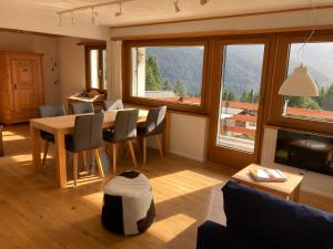 瓦尔贝拉Haus Tgamotsch***- Ferienwohnung in Valbella的客厅配有桌椅和窗户。