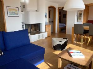 瓦尔贝拉Haus Tgamotsch***- Ferienwohnung in Valbella的客厅配有蓝色的沙发和桌子