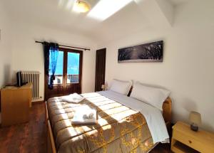 阿莱盖Hotel TEA Dolomiti的一间卧室配有一张床,上面有两条毛巾