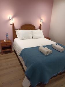 里斯本马蒂姆莫尼兹28号旅馆的一间卧室配有一张床,上面有两条毛巾