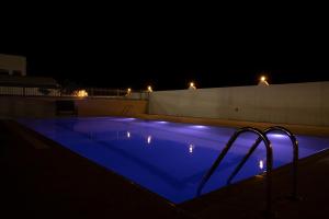 Ghubrat ŢanūfAL shoroq Green Resort的夜间游泳池,拥有蓝色照明