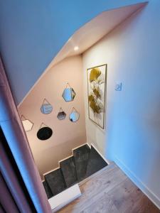 维姆勒Love Room LOsmose chambre Alchimie Bed and Breakfast Wimereux的拥有蓝色天花板的房屋内的楼梯