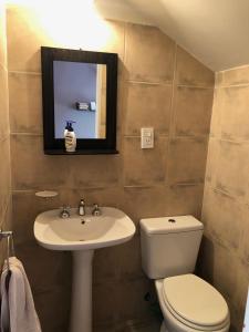 圣胡安Excelente Duplex en Consorcio Privado c/ cochera的一间带水槽、卫生间和镜子的浴室