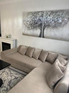 拉塔Jurata Apartament Glamour的客厅配有沙发和墙上的绘画