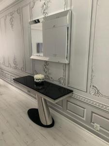拉塔Jurata Apartament Glamour的白色的房间里一张黑桌,配有橱柜