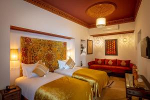 马拉喀什Riad les remparts de la kasbah的酒店客房,设有两张床和一张沙发