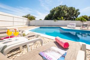 阿尔布费拉Villa Bermudas by Algarve Vacation的游泳池旁设有桌椅