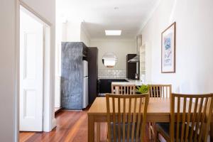 悉尼Steps from Manly Beach的厨房以及带桌椅的用餐室。