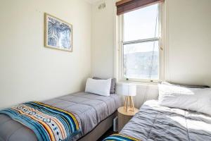 悉尼Steps from Manly Beach的一间卧室设有两张床和窗户。