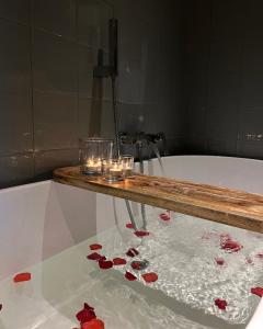 米德尔堡Logies aan de Dam的浴缸配有蜡烛和红色玫瑰脚踏