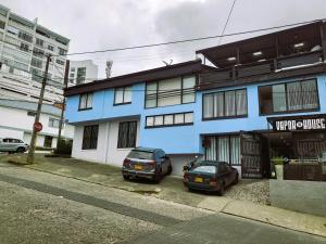 马尼萨莱斯Casa Azul的两辆汽车停在蓝色建筑前面