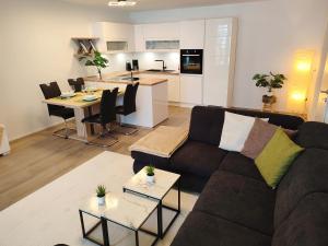 上陶恩Modern Mountain Apartment - free parking & sauna的一间带棕色沙发的客厅和一间厨房