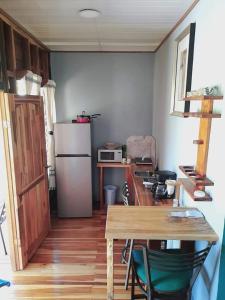 福尔图纳Bungalow Batsù的一间带桌子和冰箱的小厨房