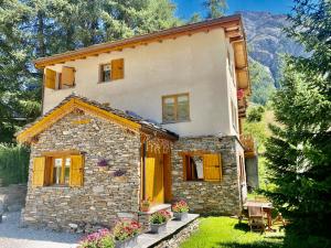 贝桑Chalet Les Cocales Résidence Séjour et nuitées B&B - Appartement Pin Cembro的一边有黄色百叶窗的石头房子