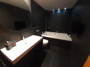 哈卡Los Sauces III的浴室配有盥洗盆、卫生间和浴缸。