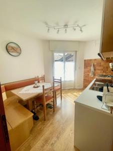 卡瓦莱塞Tina's House - Alpine Stay Apartments的一间带桌子的厨房和一间餐厅