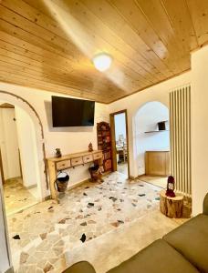 卡瓦莱塞Tina's House - Alpine Stay Apartments的客厅设有木制天花板和平面电视。