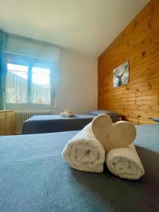 卡瓦莱塞Tina's House - Alpine Stay Apartments的床上心形毛巾