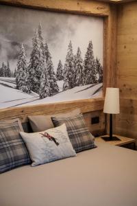 博尔米奥Sci Sport rooms & suites的卧室拥有雪覆盖森林的壁画