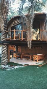 Al Muţayrifīمنتجع اكواخ النخيل的带阳台和棕榈树的度假建筑