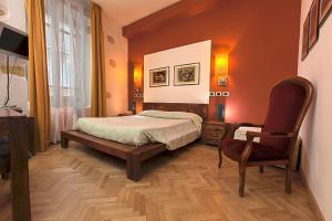 卡利亚里Maison Savoia B&b Apartment的一间卧室配有一张床和一把椅子