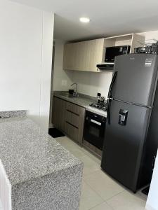 布卡拉曼加Apartamento privado con vista en el centro de B/ga的厨房配有黑色冰箱和炉灶。