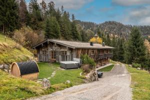 凯撒山麓舍福Luxury old wood mountain chalet in a sunny secluded location with gym, sauna & whirlpool的山丘上的房子,前面有一条路