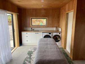 新普利茅斯Mangorei Heights - New Plymouth的房屋内的厨房,配有洗衣机和烘干机