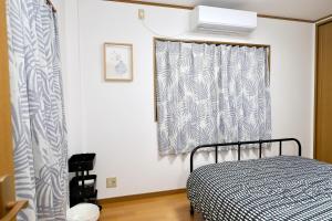 大阪Guest House Kubo Homes Matsu的一间卧室设有一张床和一个窗口