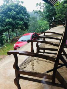 康提Little wood villa Doluwa的坐在门廊上的长凳,后面有一辆汽车