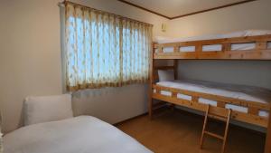 白马村Yuhike House Misorano的一间卧室设有两张双层床和一扇窗户。