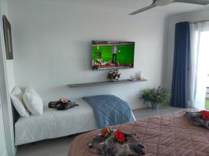 伊科德洛斯维诺斯Playa Monis 1的一间设有两张床和一台墙上电视的房间