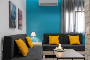 干尼亚Chania Design Suites的客厅配有黑色沙发和黄色枕头