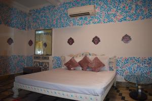 焦特布尔Haveli的一间卧室配有蓝色和白色壁纸的床
