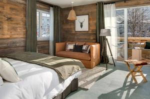 巴特欣德朗MOUNTAIN LODGE OBERJOCH, BAD HINDELANG - moderne Premium Wellness Apartments im Ski- und Wandergebiet Allgäu auf 1200m, Family owned, 2 Apartments mit Privat Sauna的一间卧室配有一张床和一把椅子