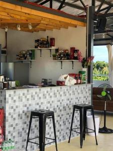 宿务Caza De Sierra-Home Staycation的厨房在柜台前设有两张凳子