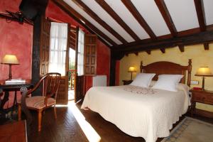 桑提亚纳德玛拉卡萨迪尔奥尔甘尼斯特乡村别墅的一间卧室配有一张床、一张桌子和一张书桌