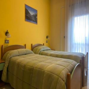 阿塞尔吉Hotel Giampy的黄色墙壁客房的两张床