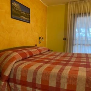 阿塞尔吉Hotel Giampy的一间卧室配有一张带 ⁇ 子毯子的床