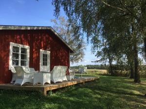 克里斯蒂娜港Karaby Gård, Country Living的甲板上带白色椅子的红色谷仓