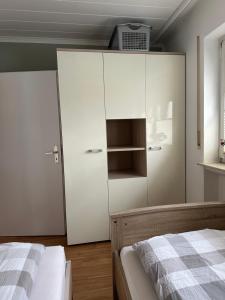 吉森FeWo-City的卧室配有白色橱柜和1张床。