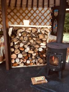 LlanbrynmairMongolian yurt sleeping 2+2 with outdoor space的炉旁的一堆柴火