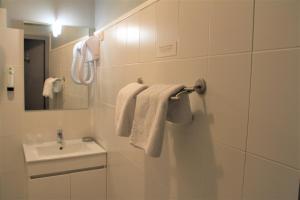 贝纳克和卡泽纳克蓬泰酒店的浴室配有盥洗盆、镜子和毛巾