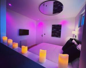 BourguébusLéa Room - Gîte Romantique - Jacuzzi的一间卧室配有一张紫色灯床