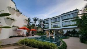 暹粒WAKA VILLA Private Resort & Spa - Adults Only的一座带游泳池和大楼的酒店