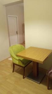 科贾埃利Grand ala otel konukevi的一张绿色椅子,坐在木桌旁